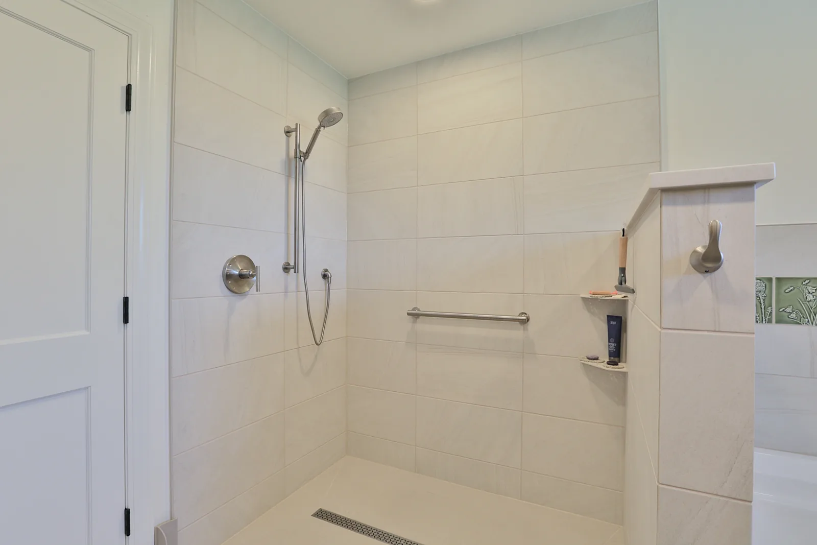 Zero-clearance threshold shower with linear drain and grab bars, built for aging in place