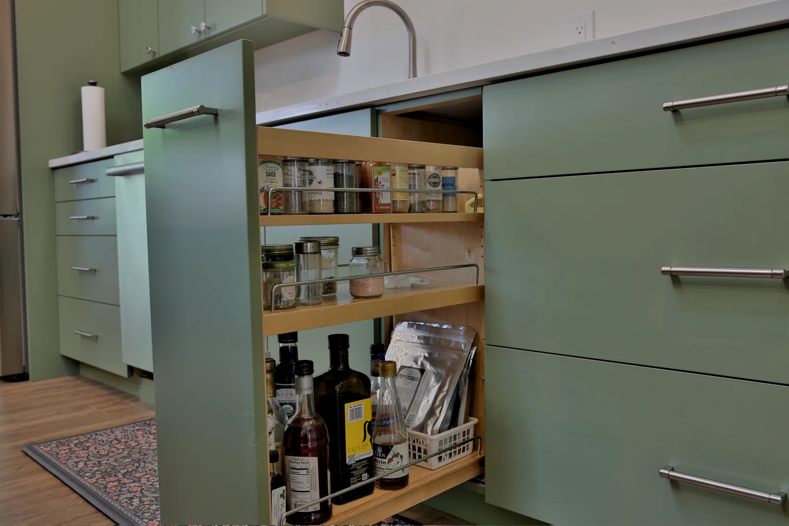 Full-height pull-out spice and pantry rack in the custom cabinetry