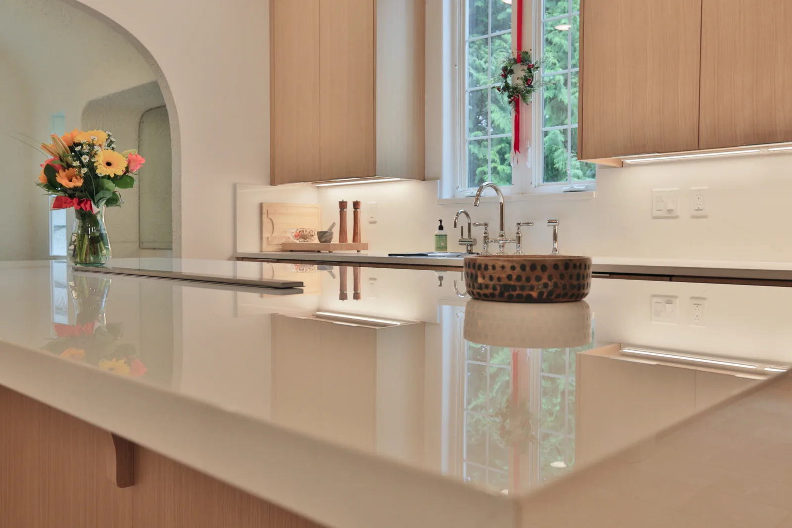 Slab porcelain island with an InvisaCook induction cooktop hidden beneath the surface