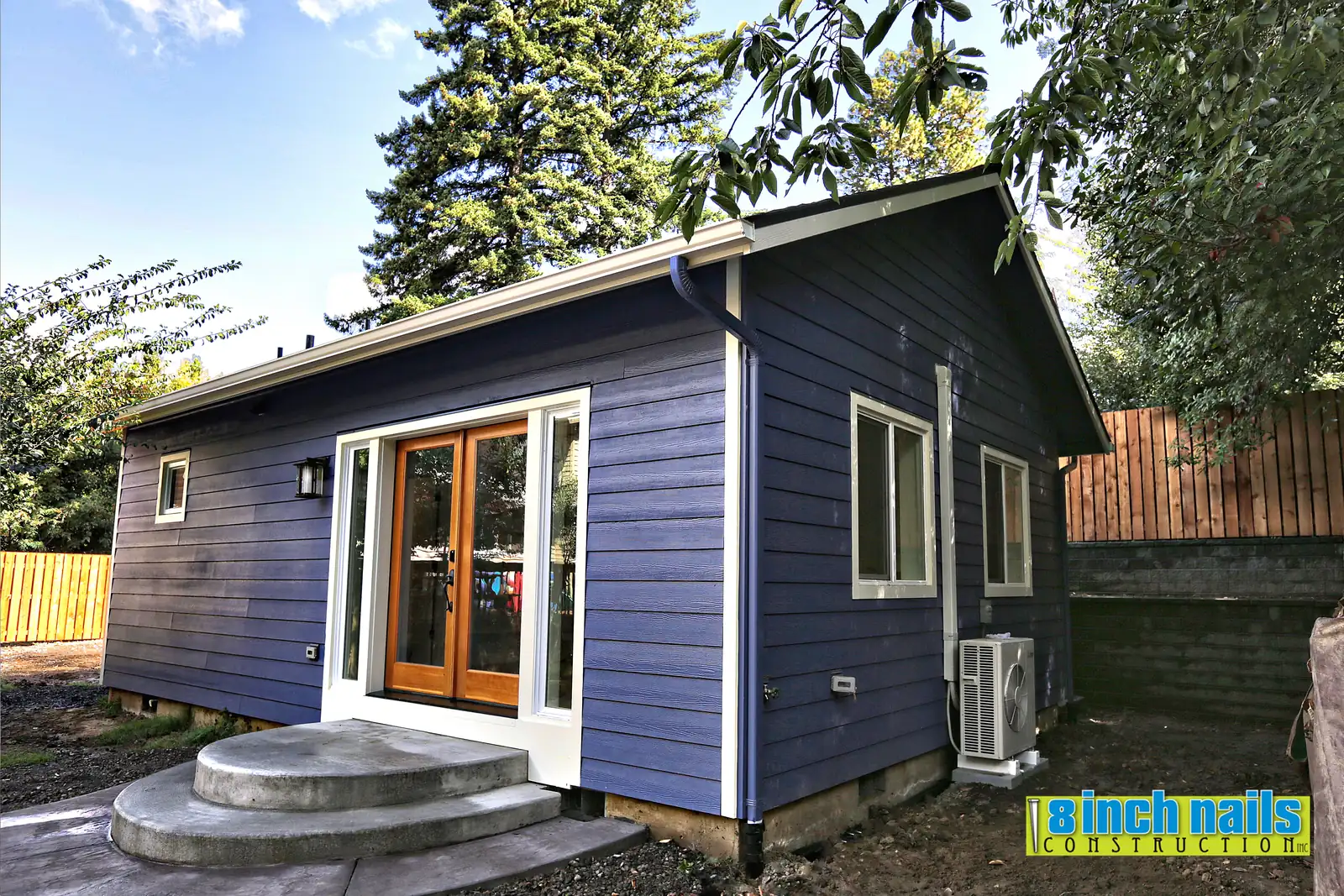 HardiePlank lap siding over a vented rainscreen on the Tigard ADU, with the heat pump condenser