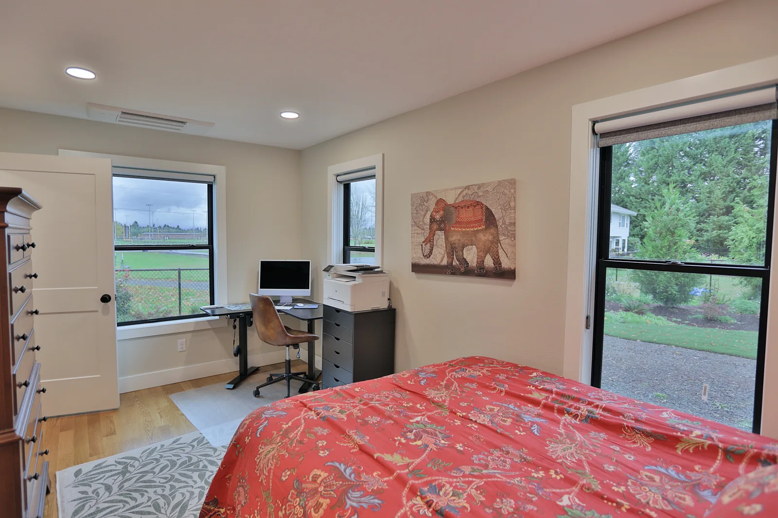 Second bedroom used as an office, with windows on two walls