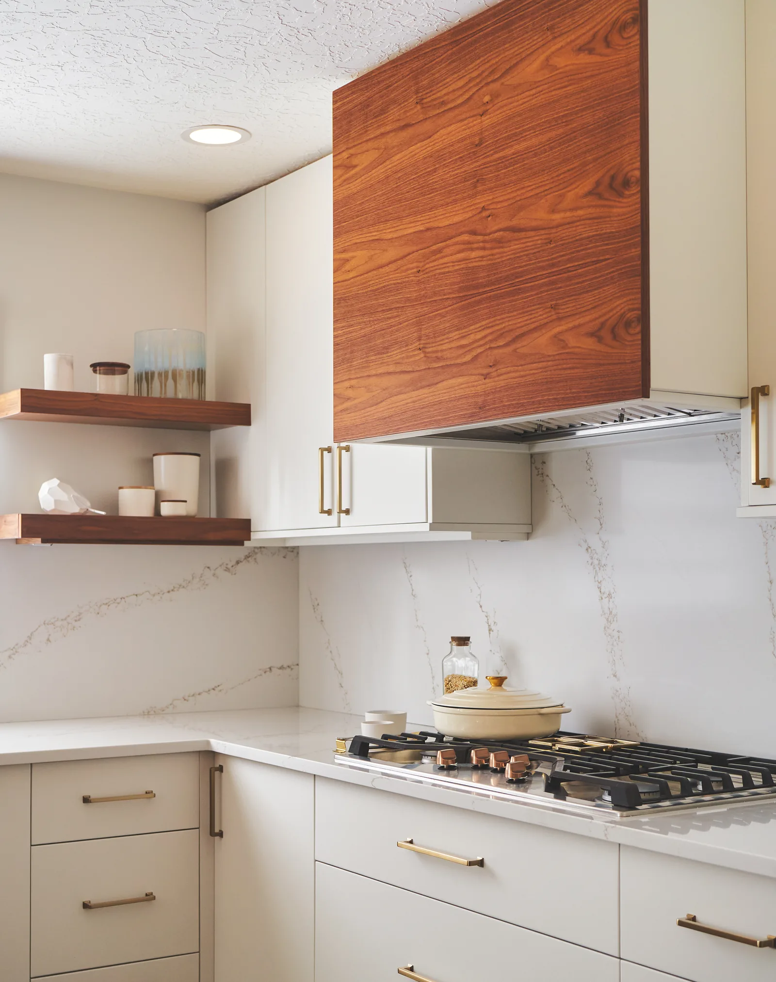 Lake Oswego kitchen with a walnut hood surround, quartz backsplash run full height, and brass pulls