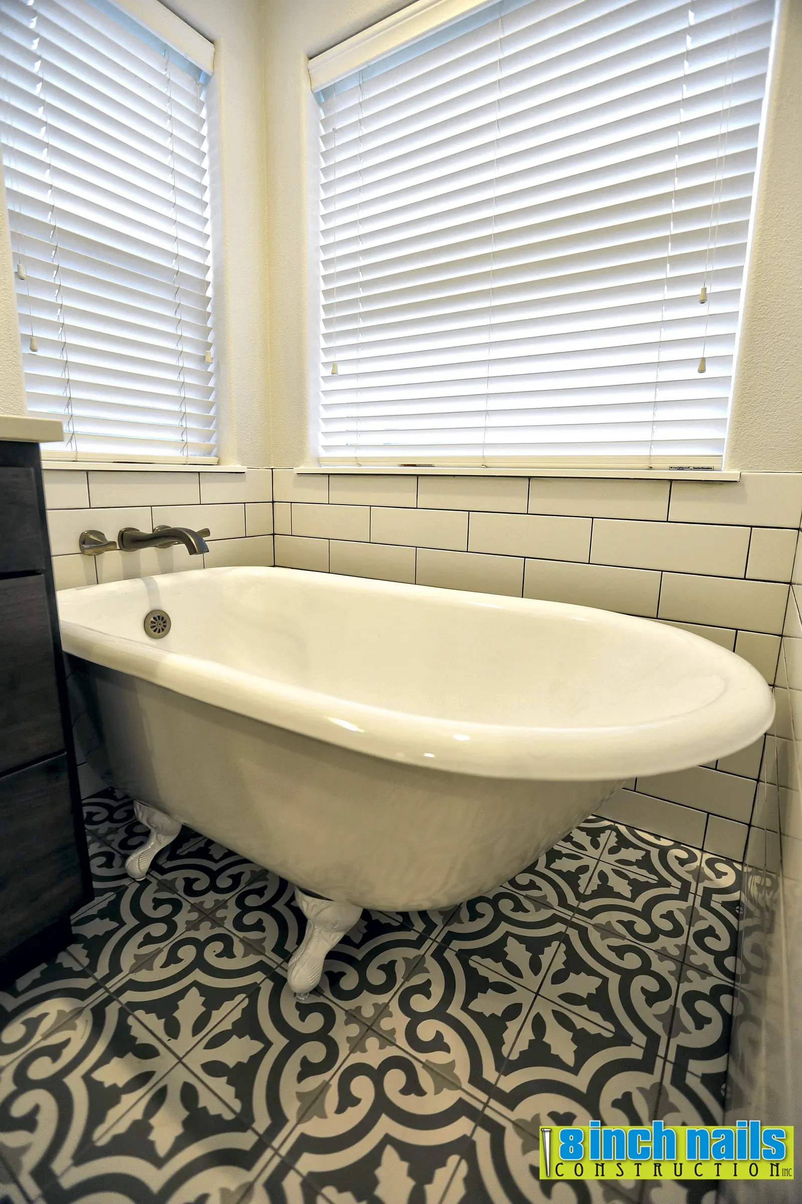 Freestanding clawfoot tub with a wall-mounted filler over patterned encaustic-look floor tile