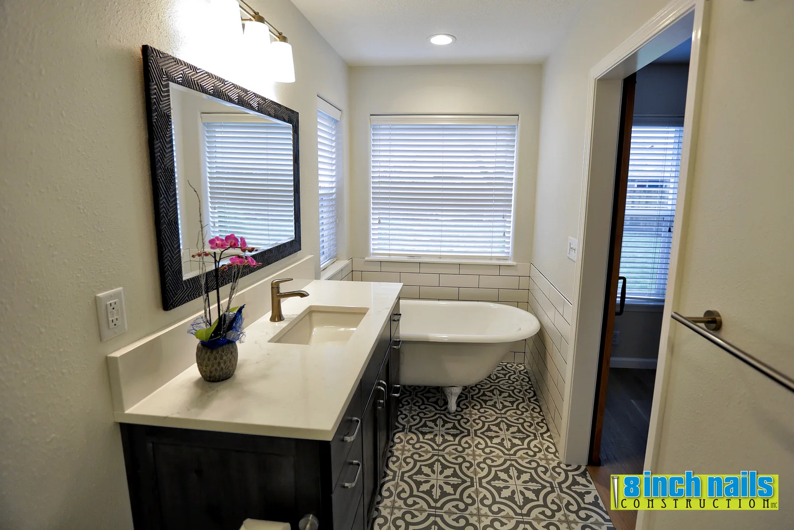 Remodeled bathroom in Hillsboro, OR with a dark vanity, quartz counter and a clawfoot tub